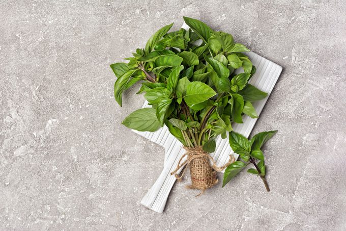 Basil on white wooden board
