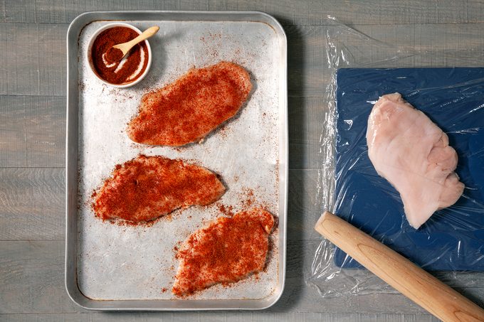 Spice mixture sprinkled over the raw chicken breasts