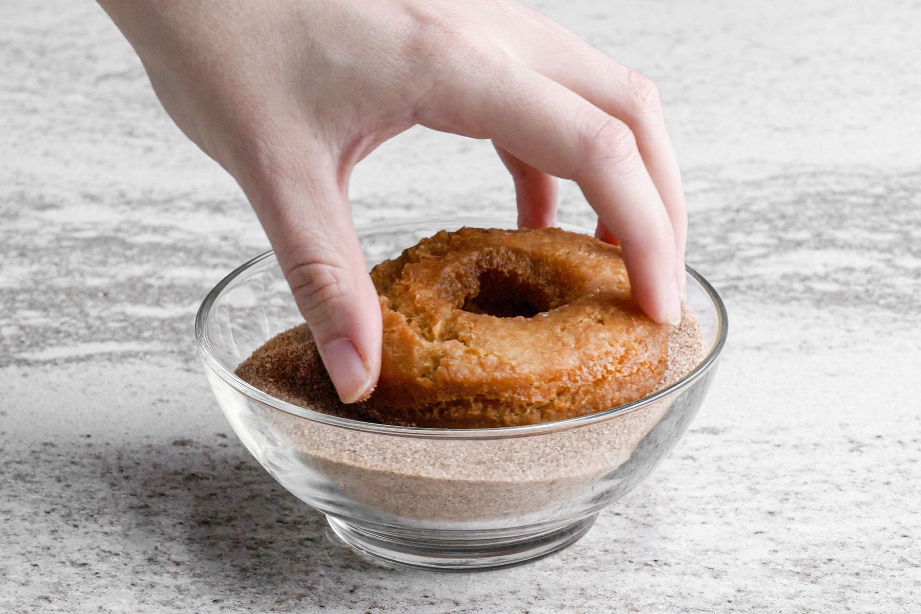 Dipping the doughnuts in sugar