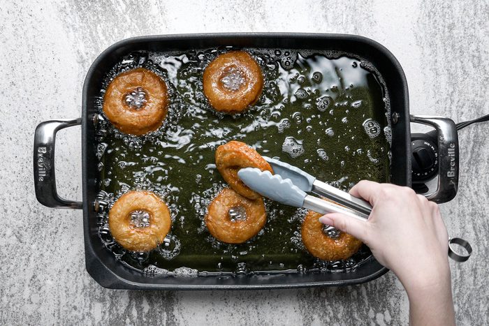 Frying the doughnuts until golden brown