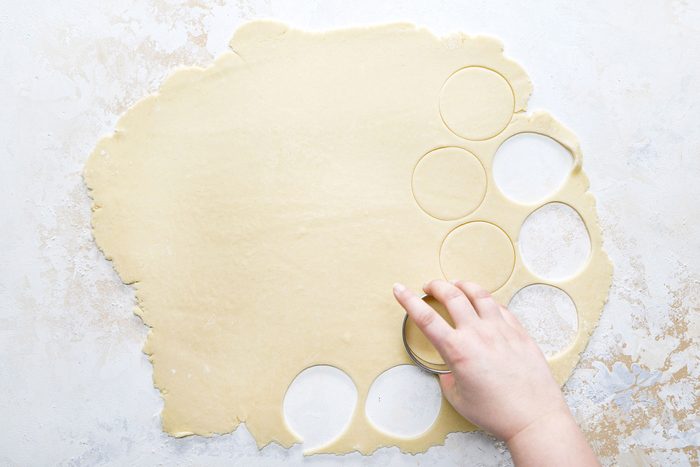 Cutting the dough round shaped with a cookie cutter.