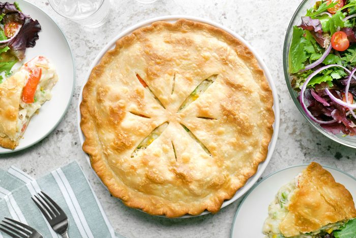 A fully baked Chicken Potpie served in a plate on a kitchen countertop.