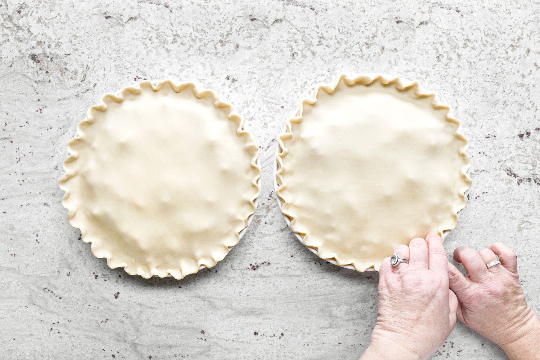 Sealing and trimming the edges of the pie crust.