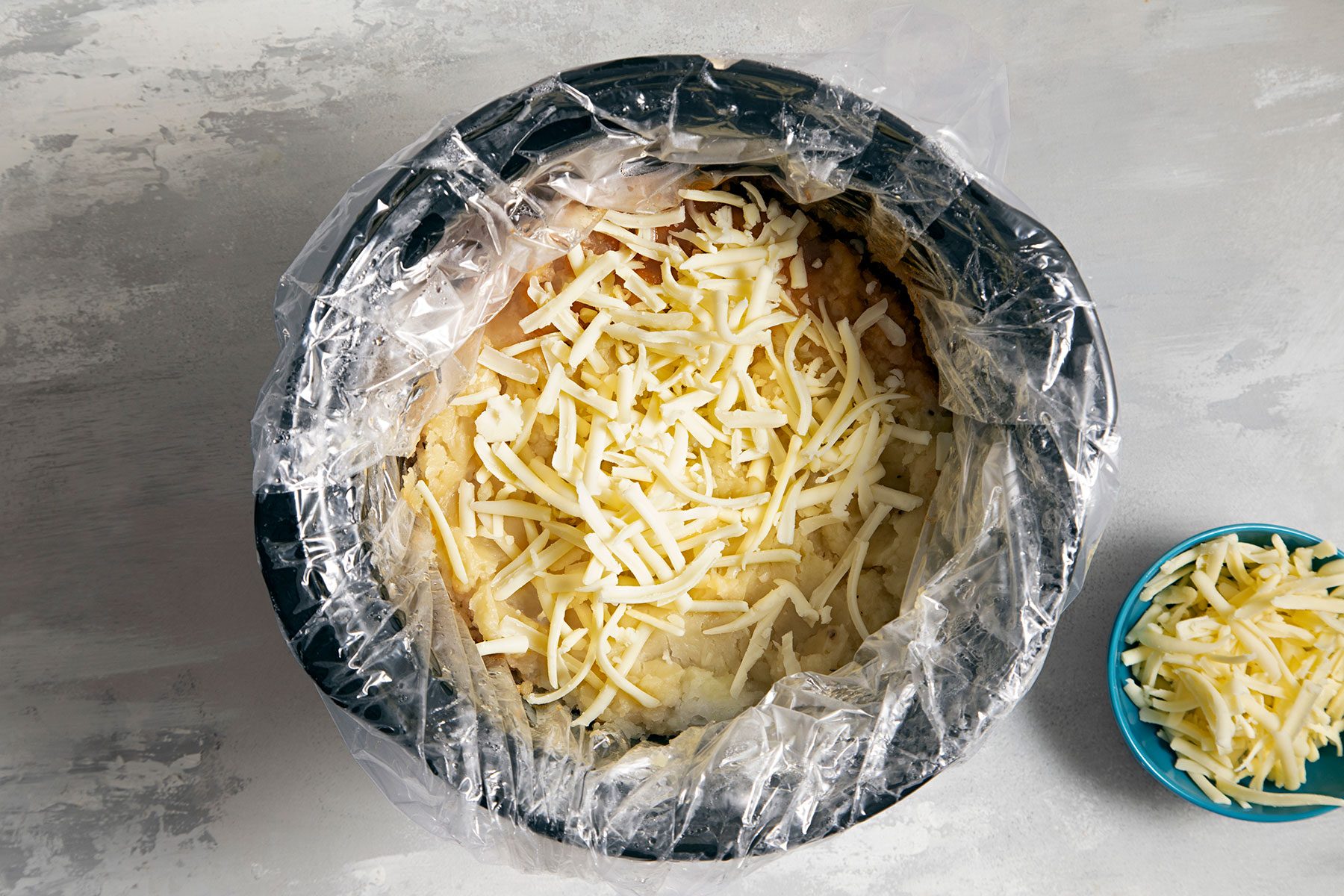 Spreading Cheese over meat mixture in slow cooker