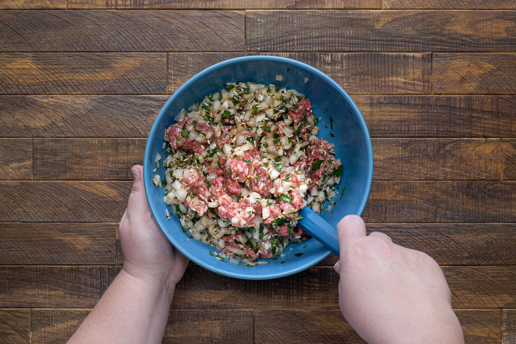 Onion, broth, uncooked rice and other ingredients mixed in a bowl