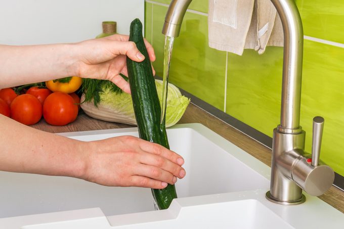 washing english cucumber in the sink
