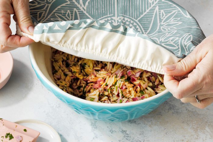 Covering the large bowl full of Orzo mixture with a cover.