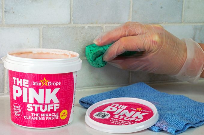A person cleaning wall with a product