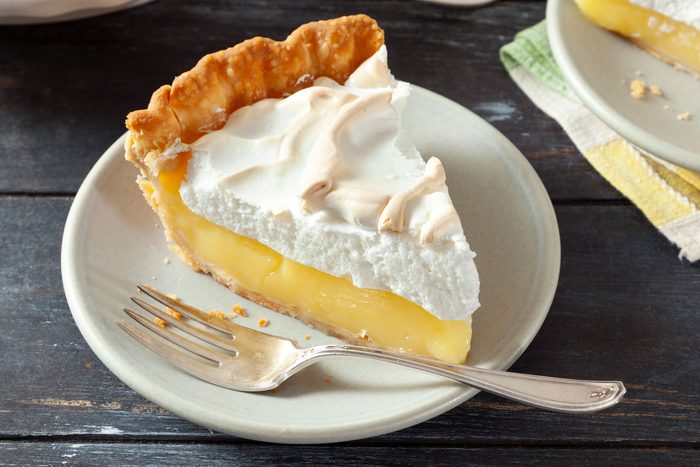 A slice of Lemon Meringue in a plate with fork