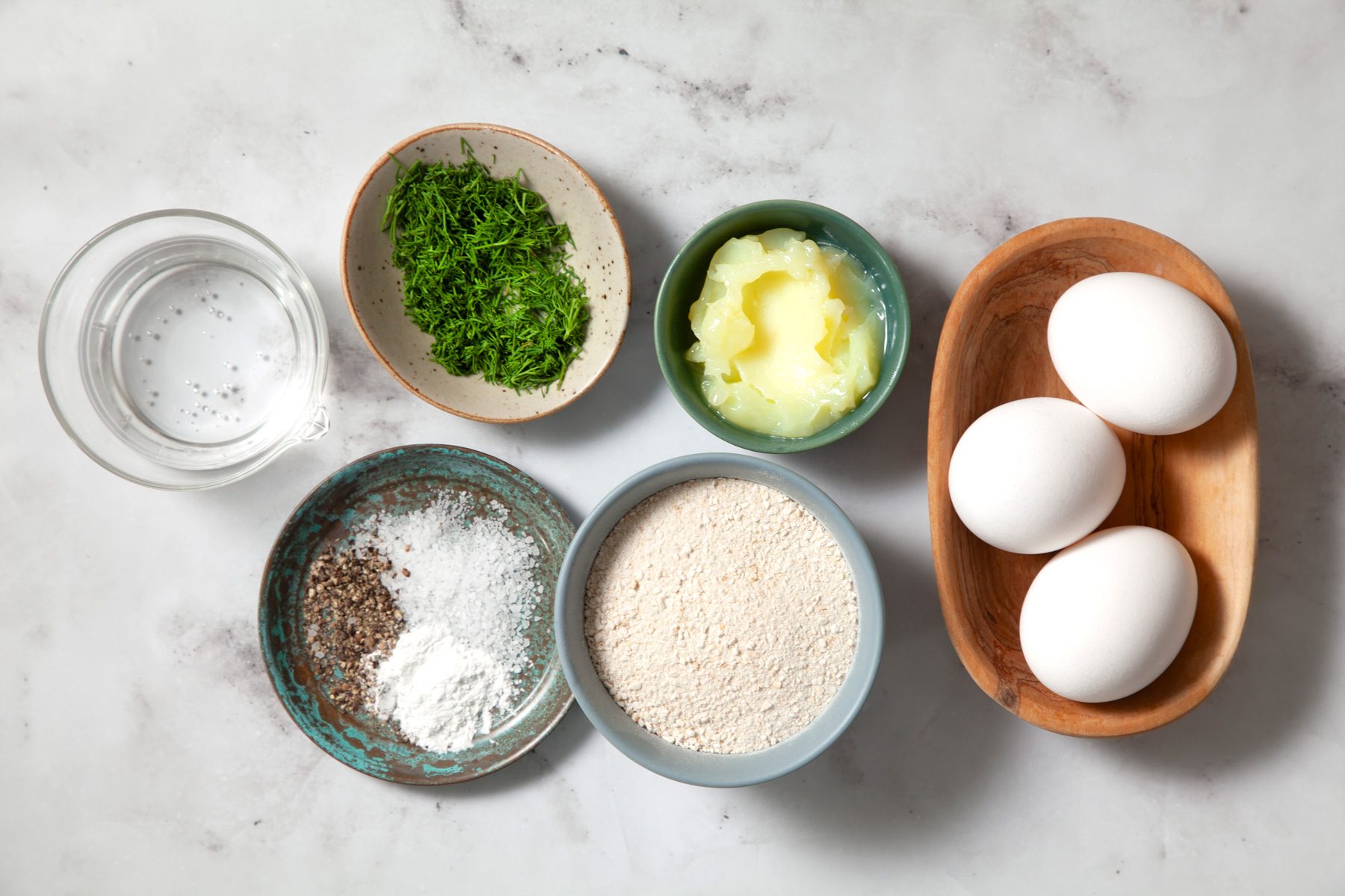 A group of bowls with eggs, neutral oil, seltzer and baking powder