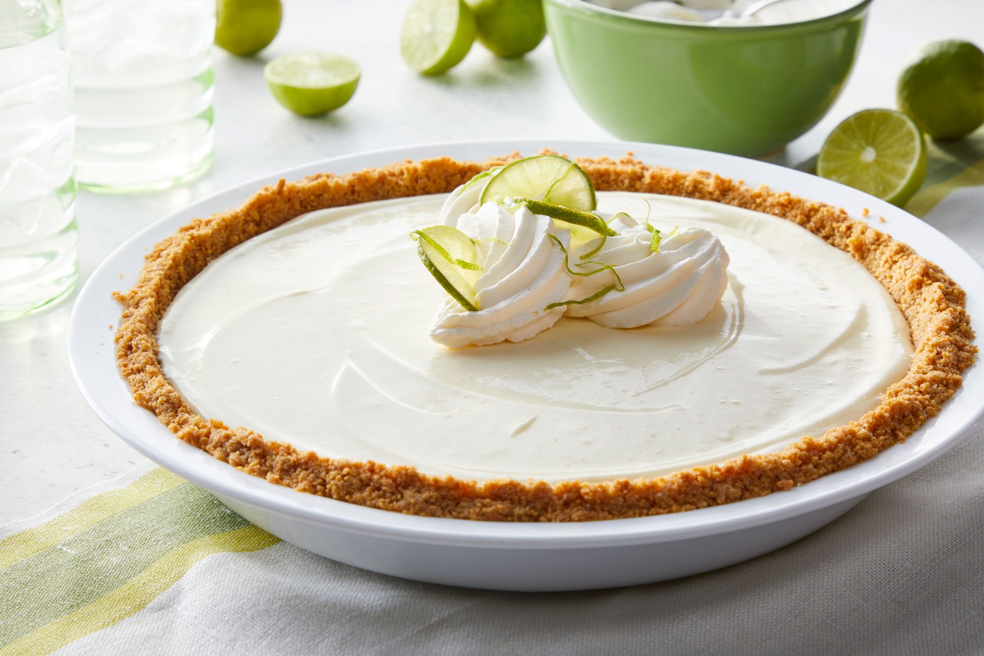 No Bake Key Lime Pie on a pie plate with some sliced lemons