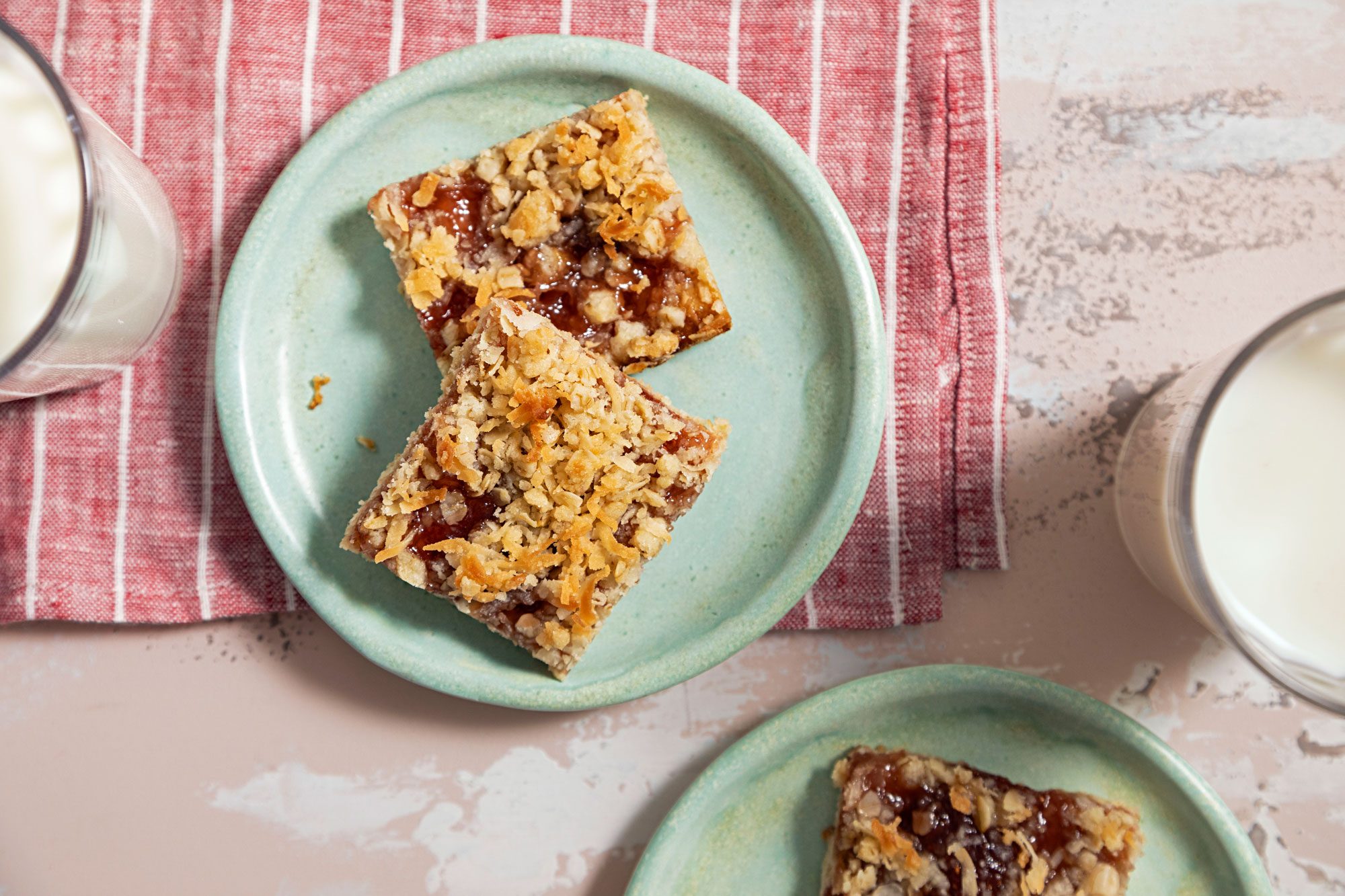 Strawberry Oatmeal Bars Served on a Small Plate and a Glass of Milk Next to it.
