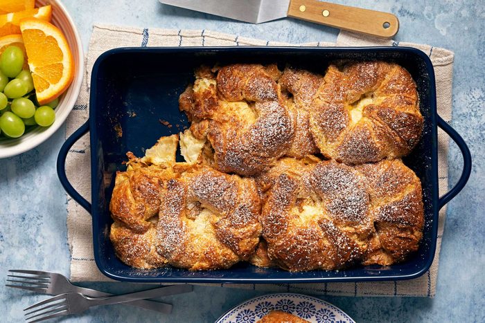 Croissant French Toast Bake in a serving pan with fruits on the side