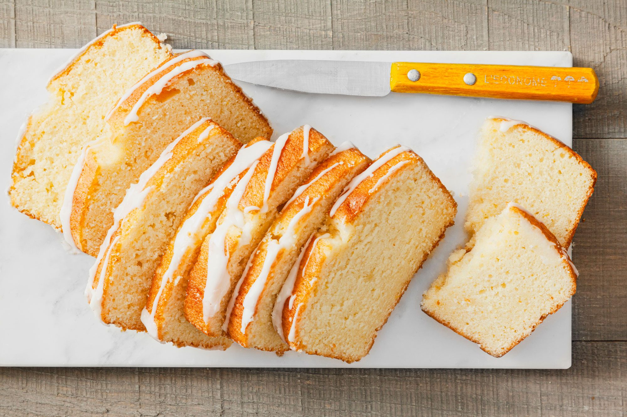 Lemon Bread with a Knife on a Marble Chopping Board on Wooden Surface