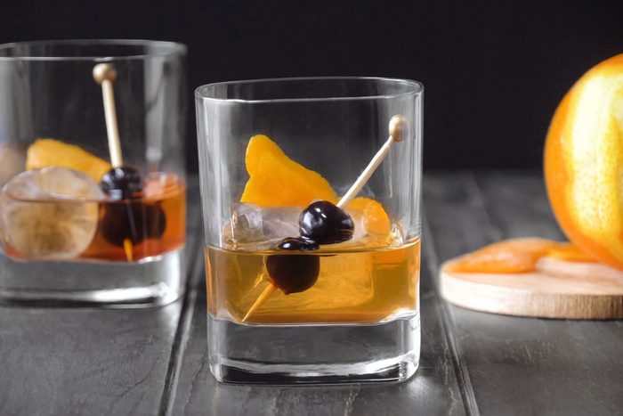 Old-Fashioned served in glasses and garnished with orange peel and cherries