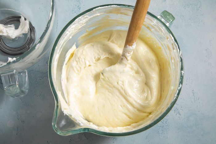 Egg mixture in a jar with a wooden spatula placed on a countertop