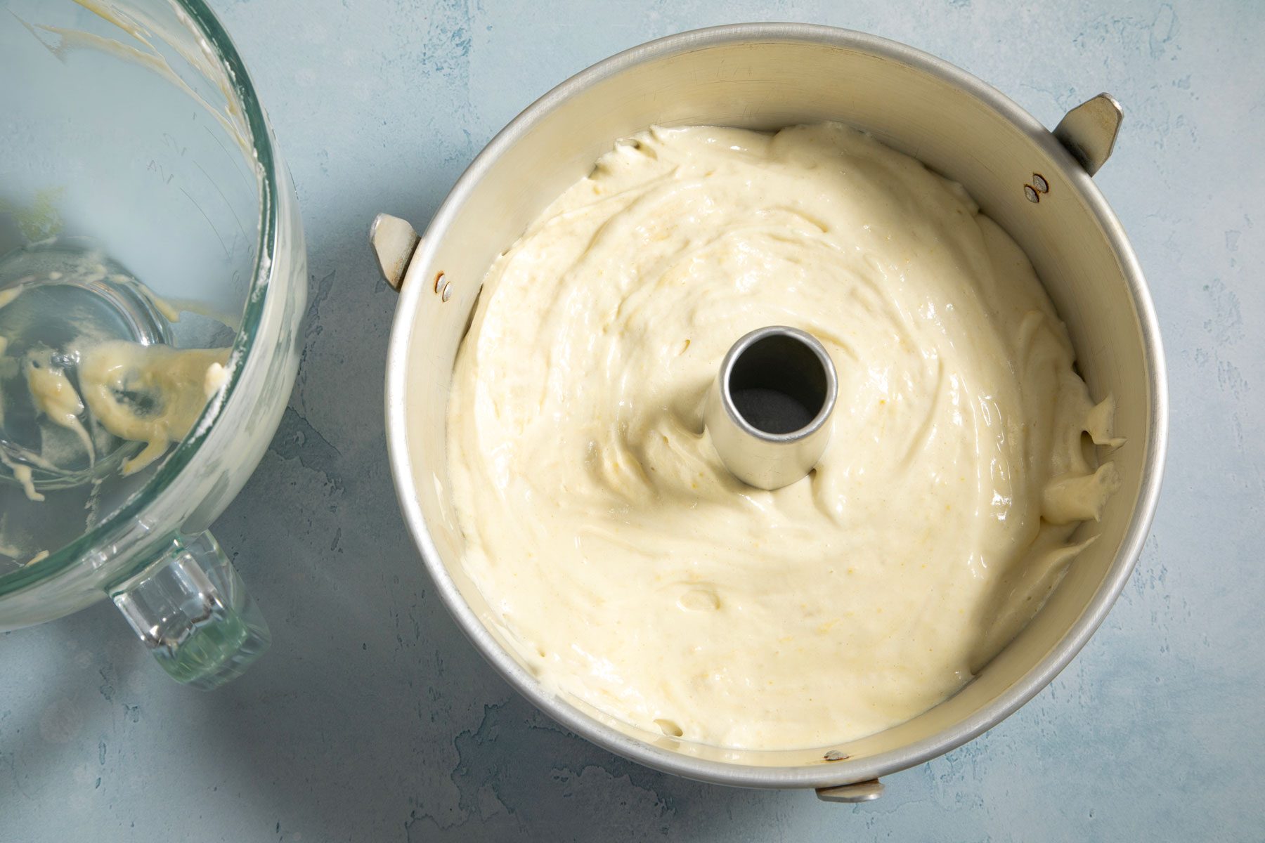 Cream mixture in a tube pan placed on counter with an empty jar