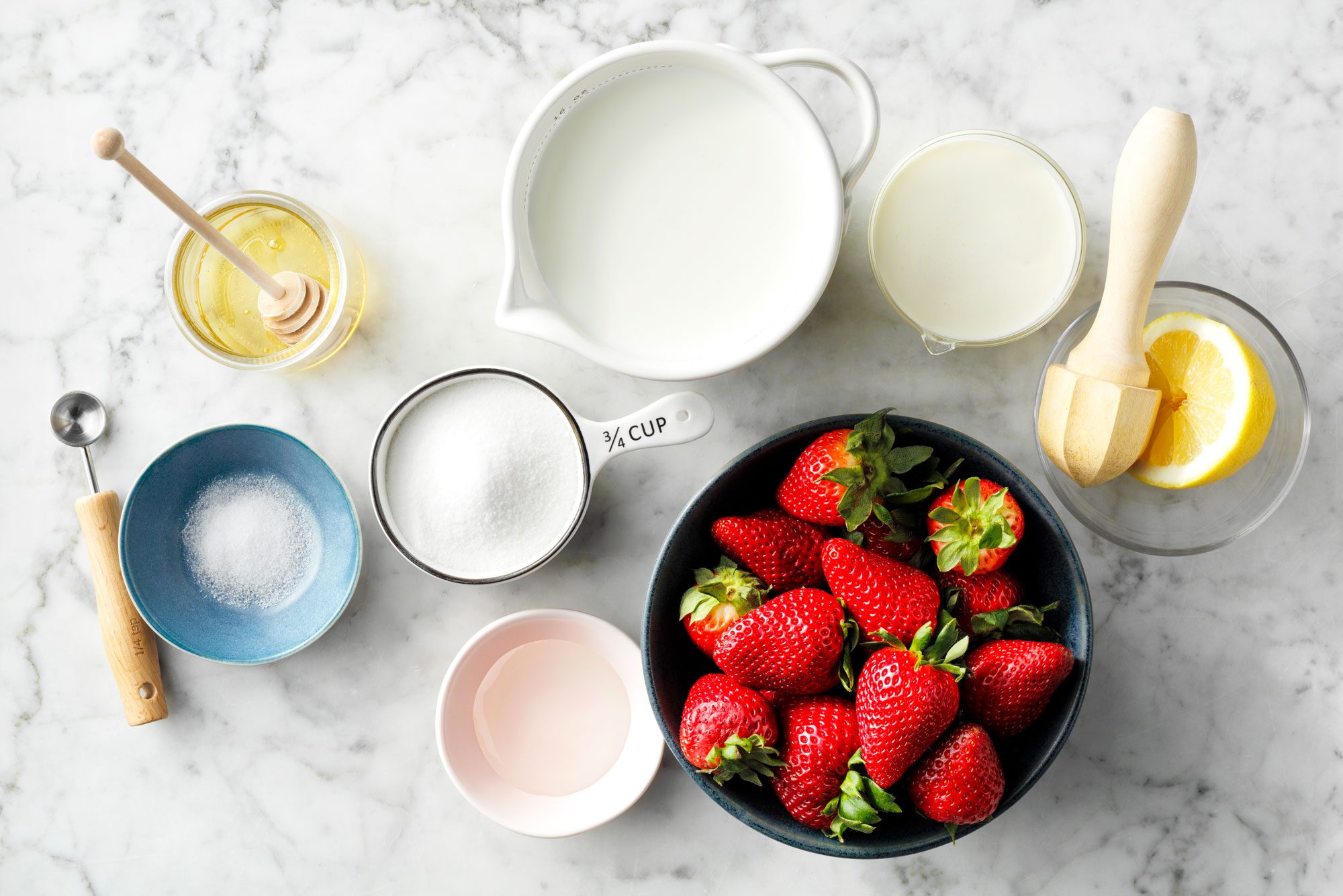 overhead shot of all ingredients for strawberry gelato on marble surface
