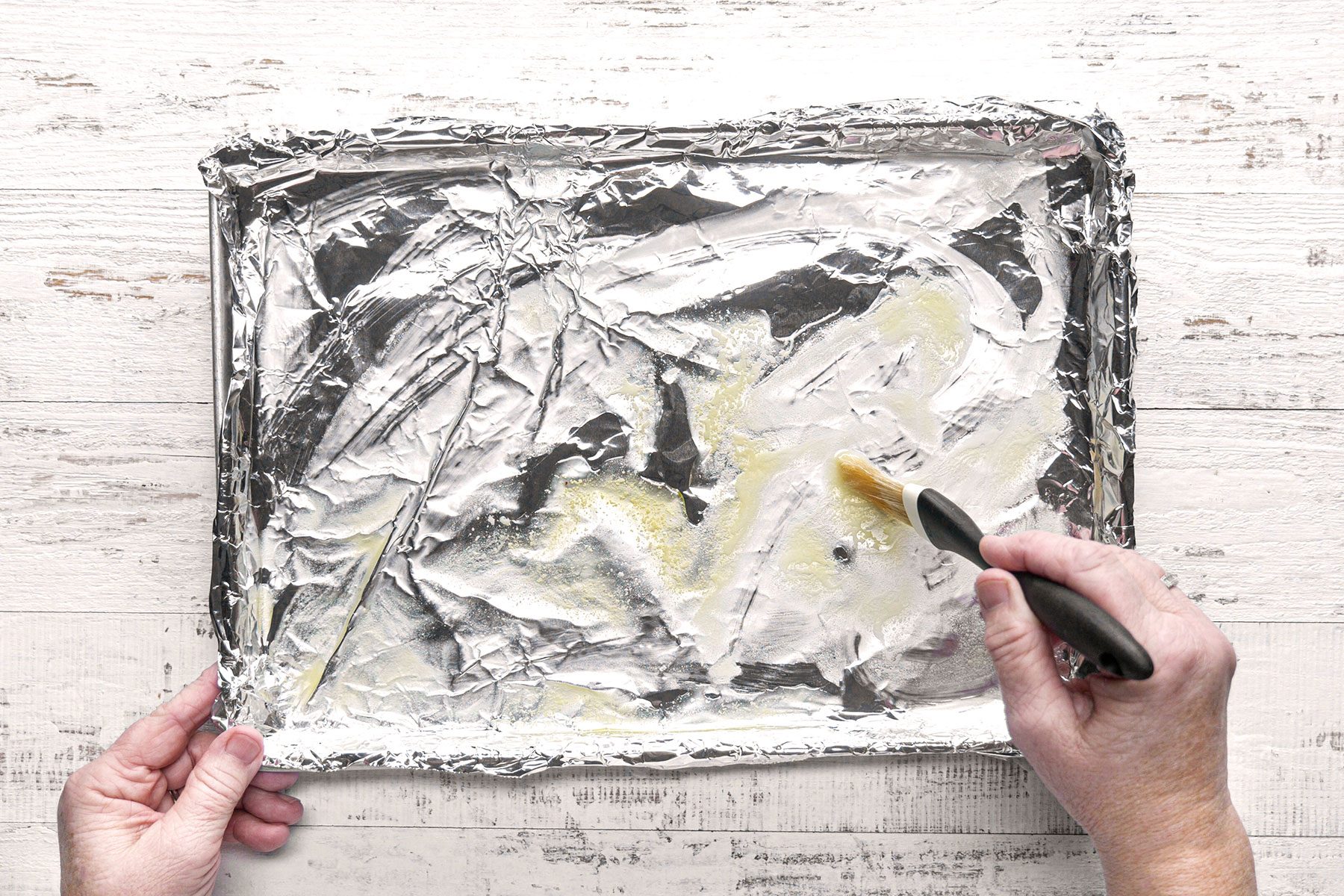 Brushing the foil paper covering the baking sheet
