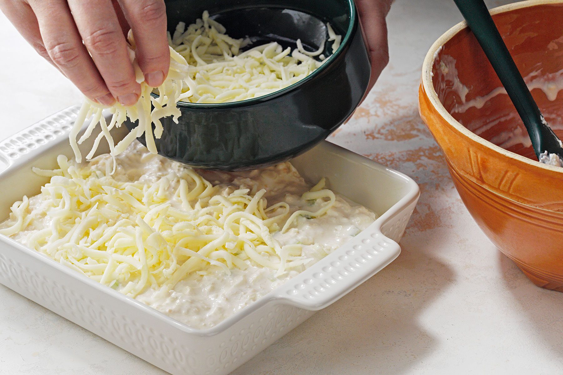 Sprinkling cheese over the mixture 