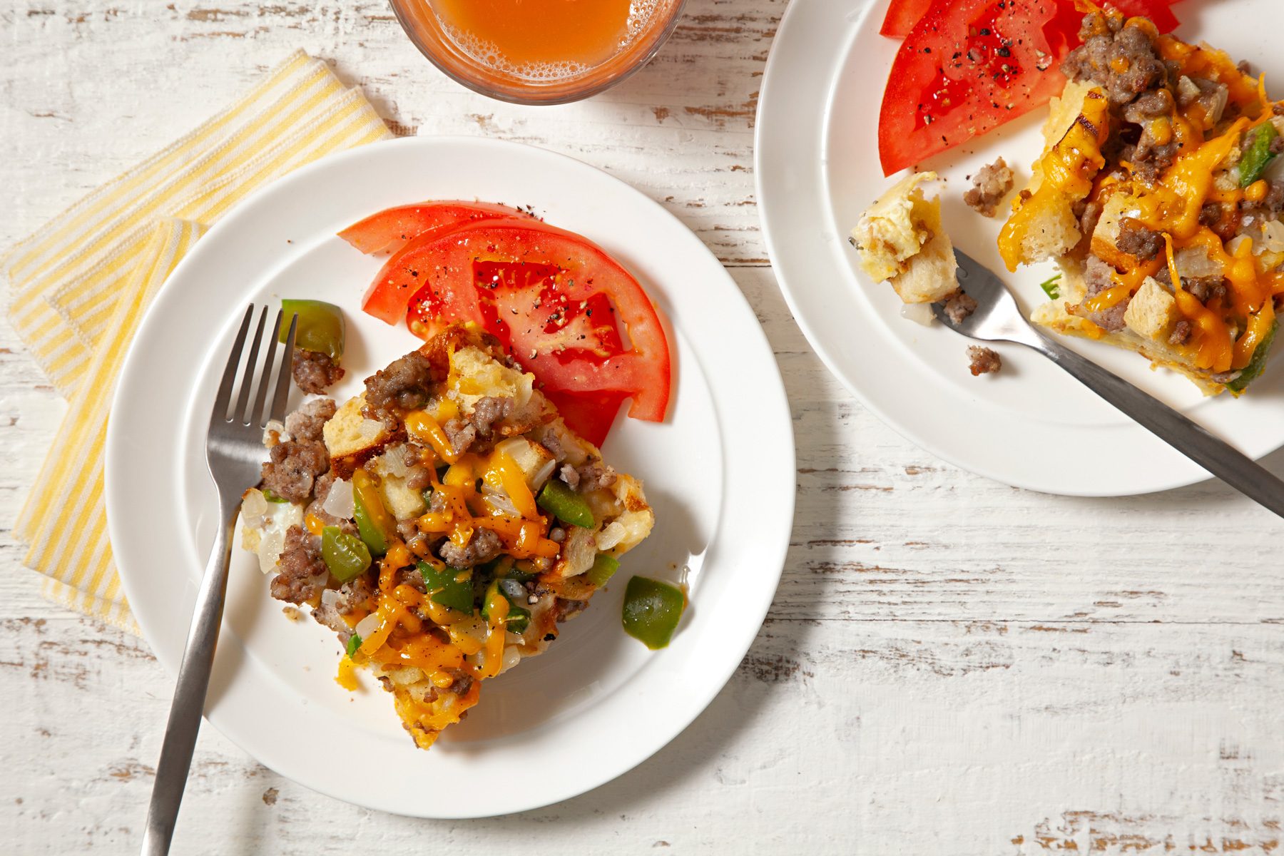 Two plates of Easy Breakfast Strata, each with a fork alongside