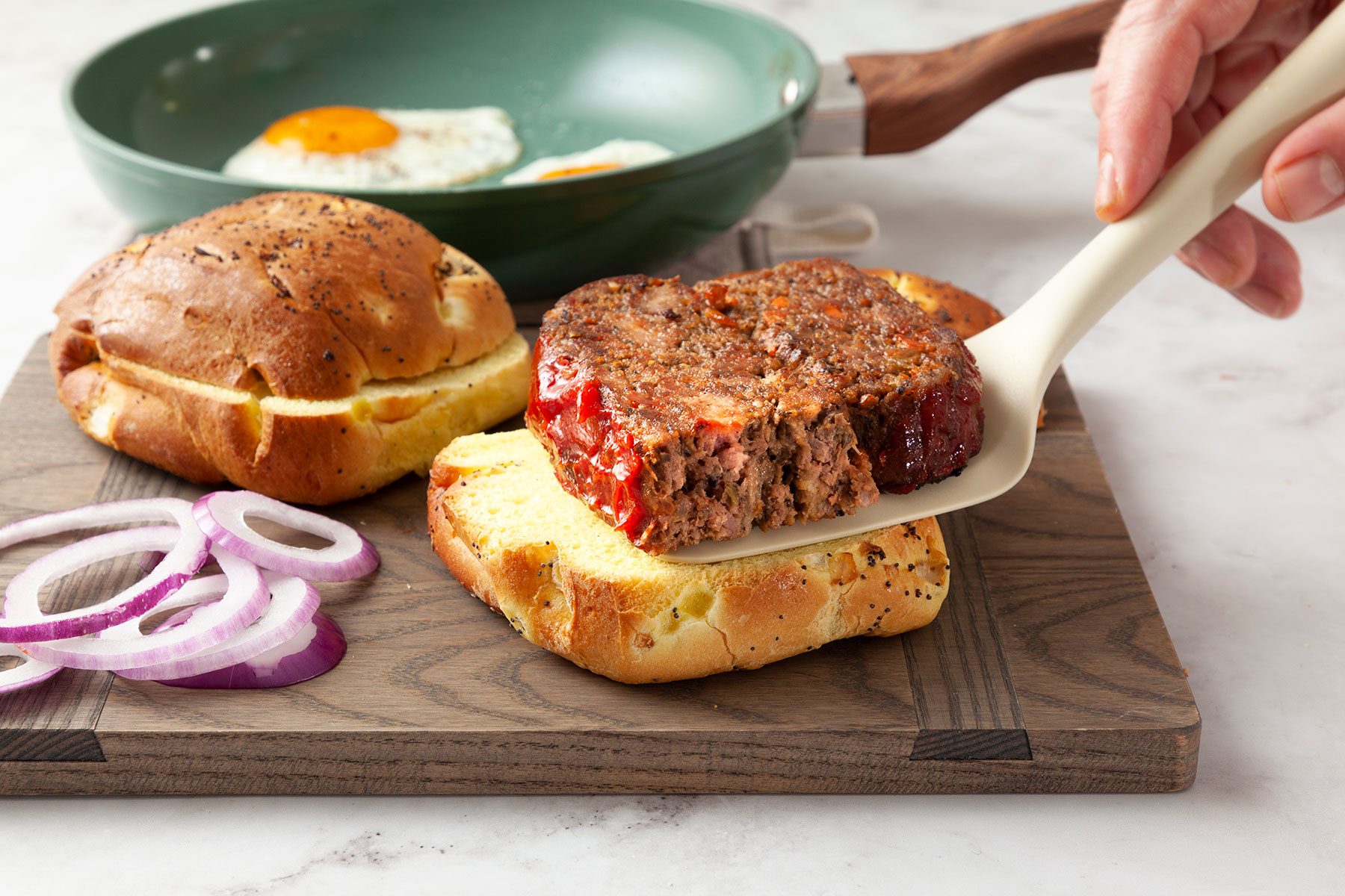 putting cooked meat on bun