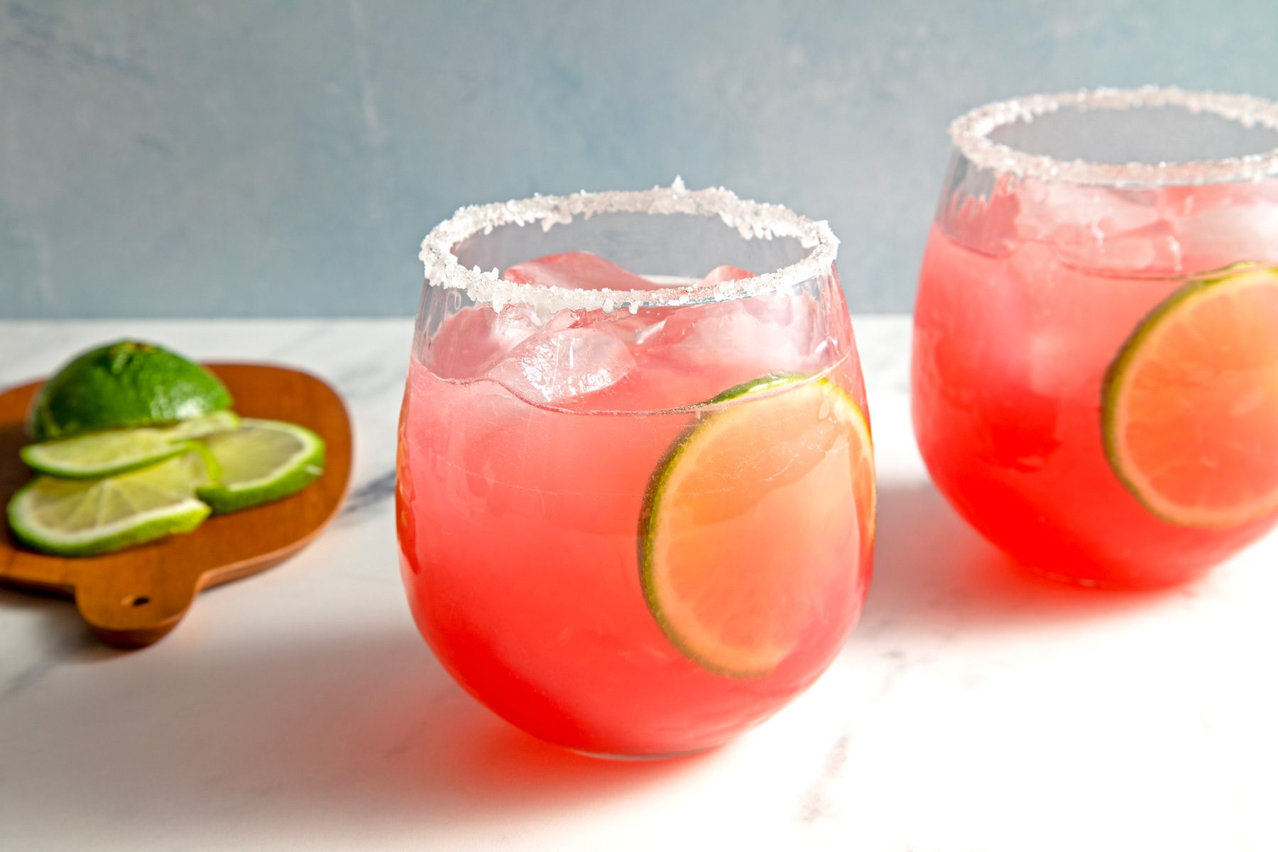 Two glass of pear margaritas garnished with lime wedges