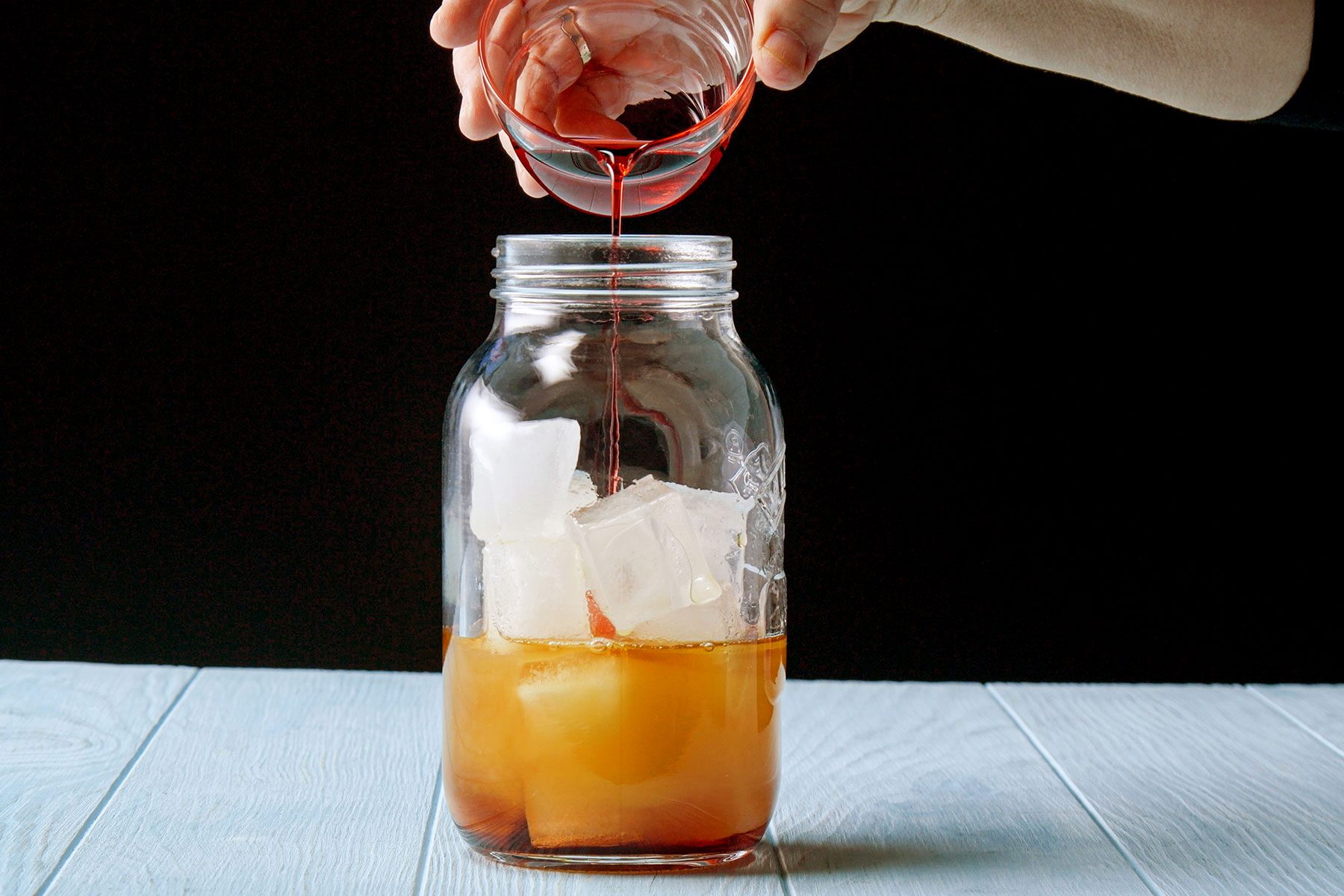 Filling up the shaker with grenadine syrup