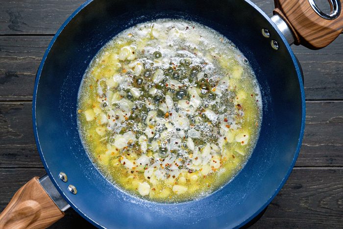 A blue pan with pasta in boiling salted water