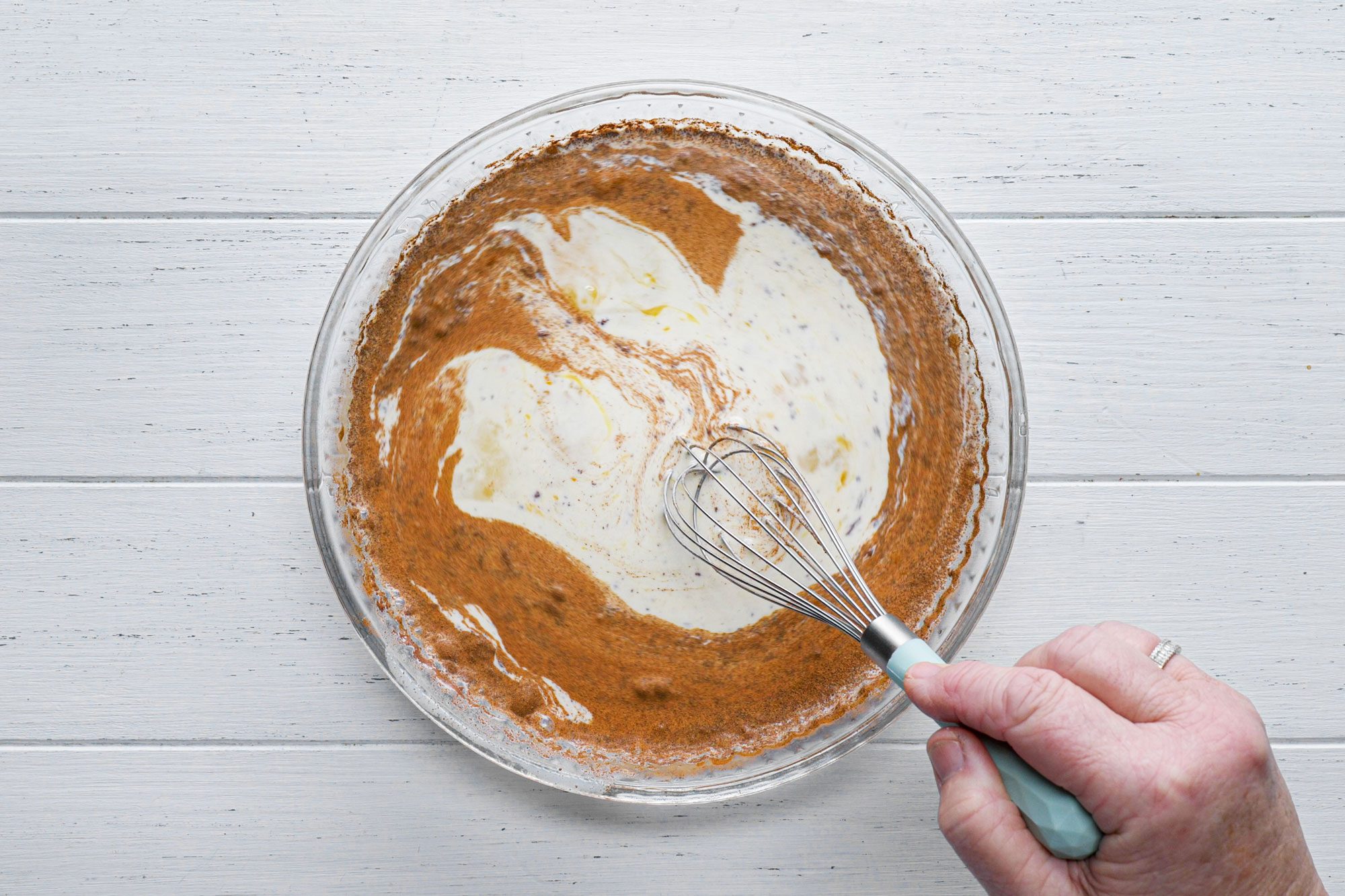 overhead shot; white background; whisking ingrediants; with whisker;