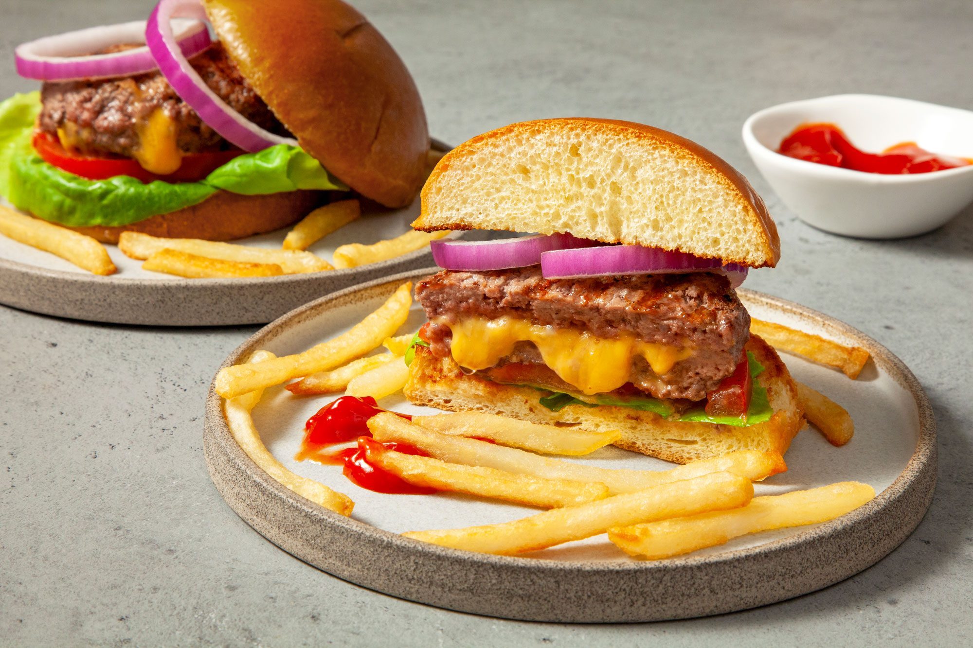 Two plates of Juicy Lucy Burger served with fries