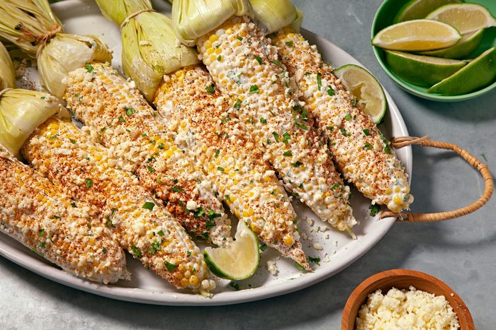 Mexican Street Corn serve on large platter with lemon wedges in a small bowl