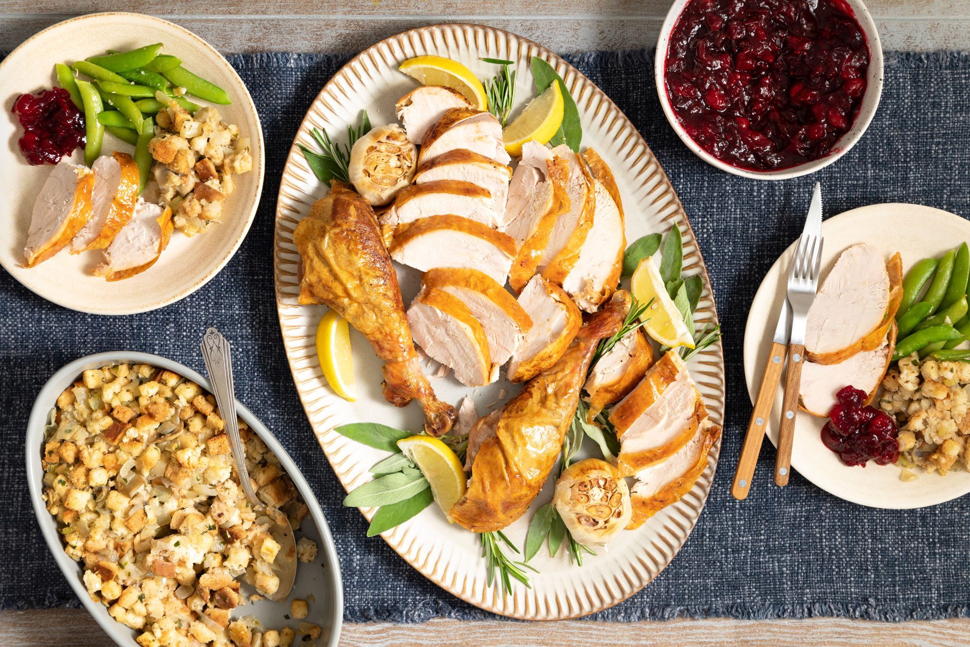 overhead shot of Stuffed Turkey Served on an oval shaped plate; kitchen napkin; wooden background;