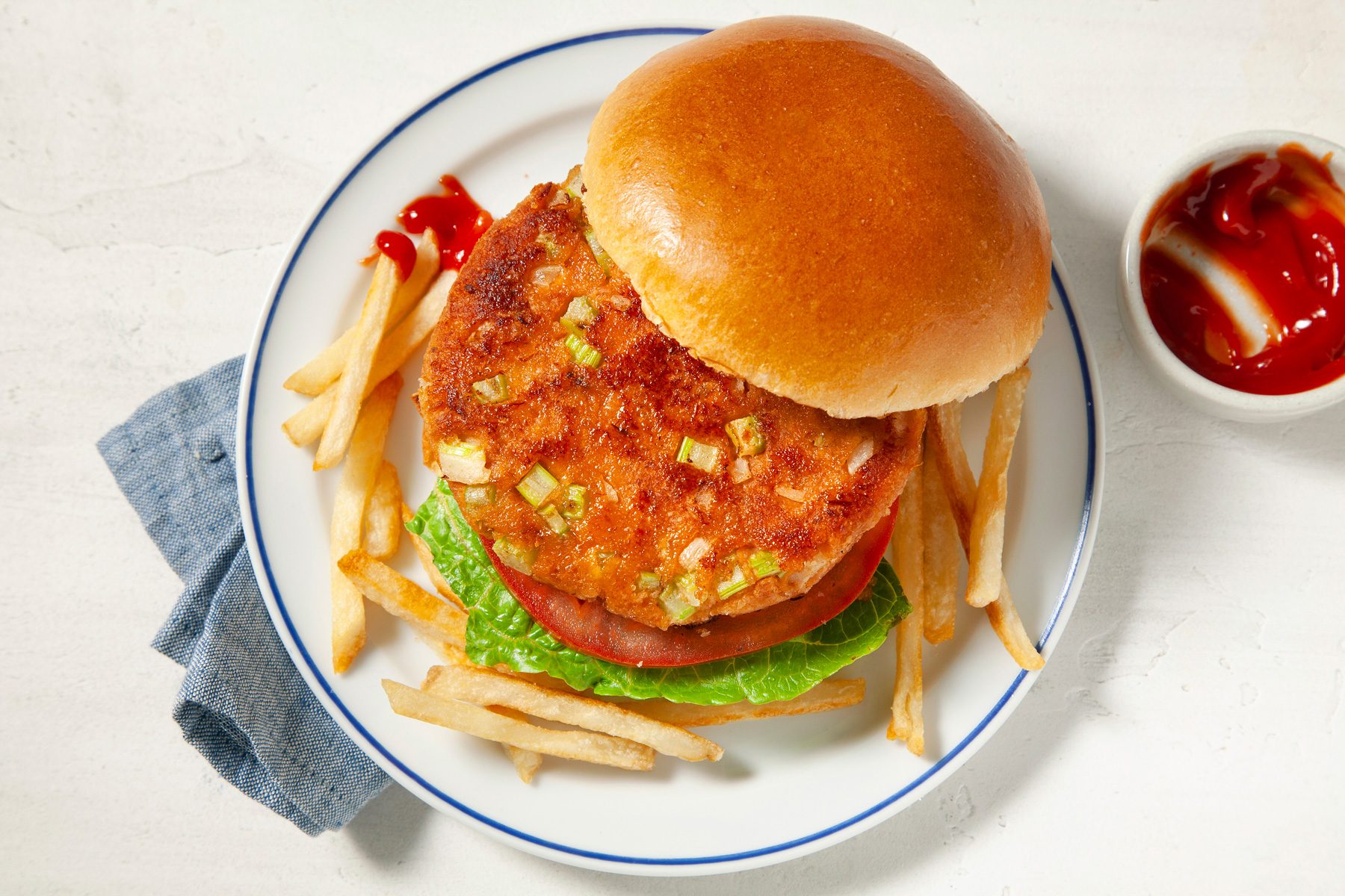 A plate of tuna burgers served with French fries and sauce