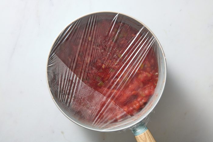 Covering the salsa with film ready for chilling