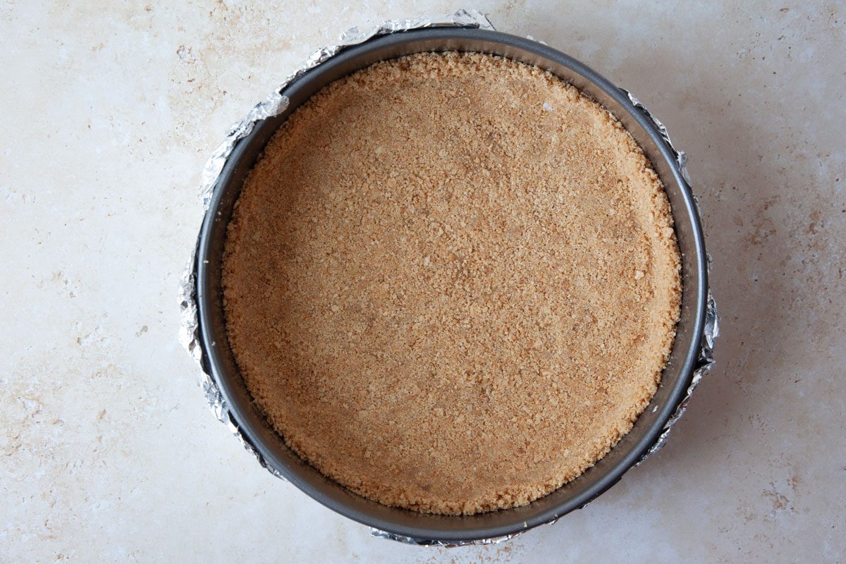 Step 2 of Taste of Home Caramel Apple Cheesecake is to make the graham cracker crust and bake it