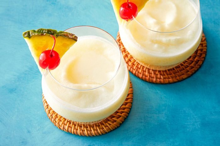 Virgin Pina Coladas in chilled glasses garnished with pineapple and cherry on coasters