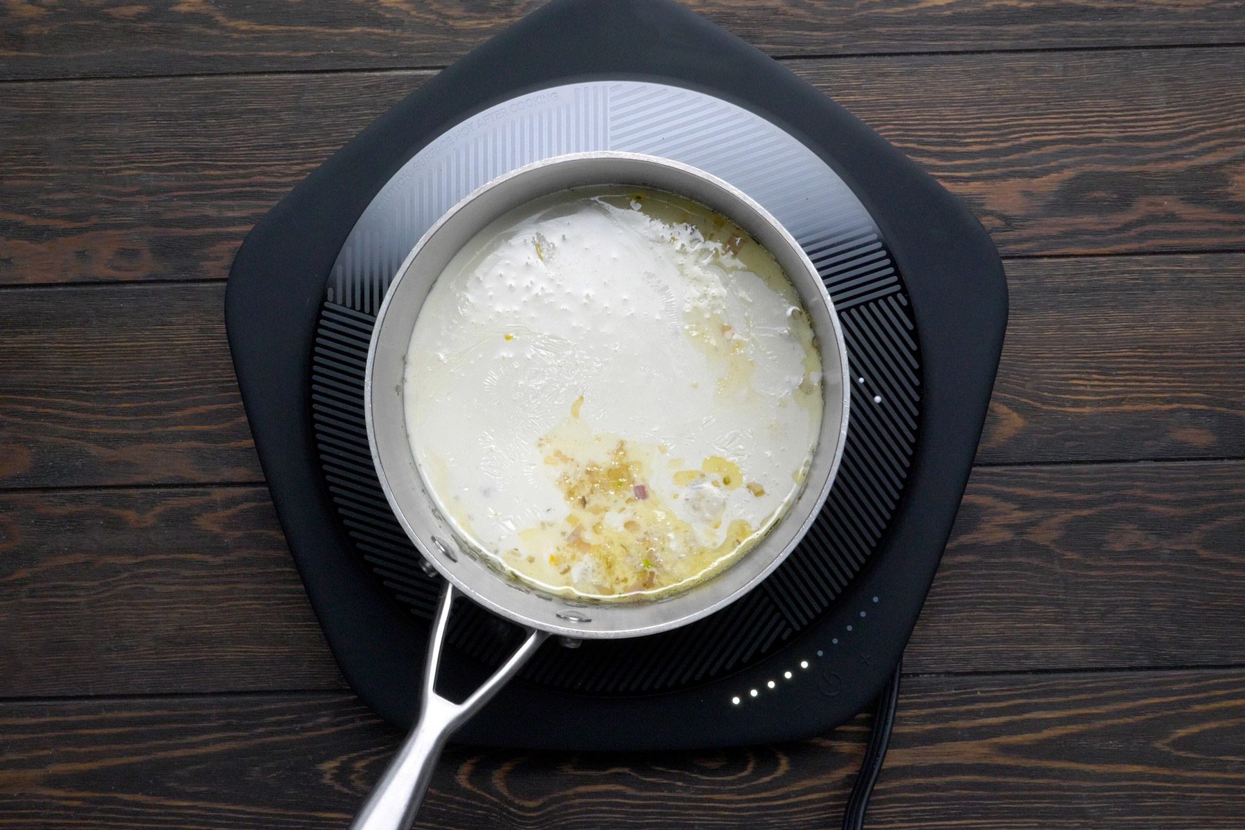 Whipping cream and cheese being added to the garlic, shallot and butter mixture.