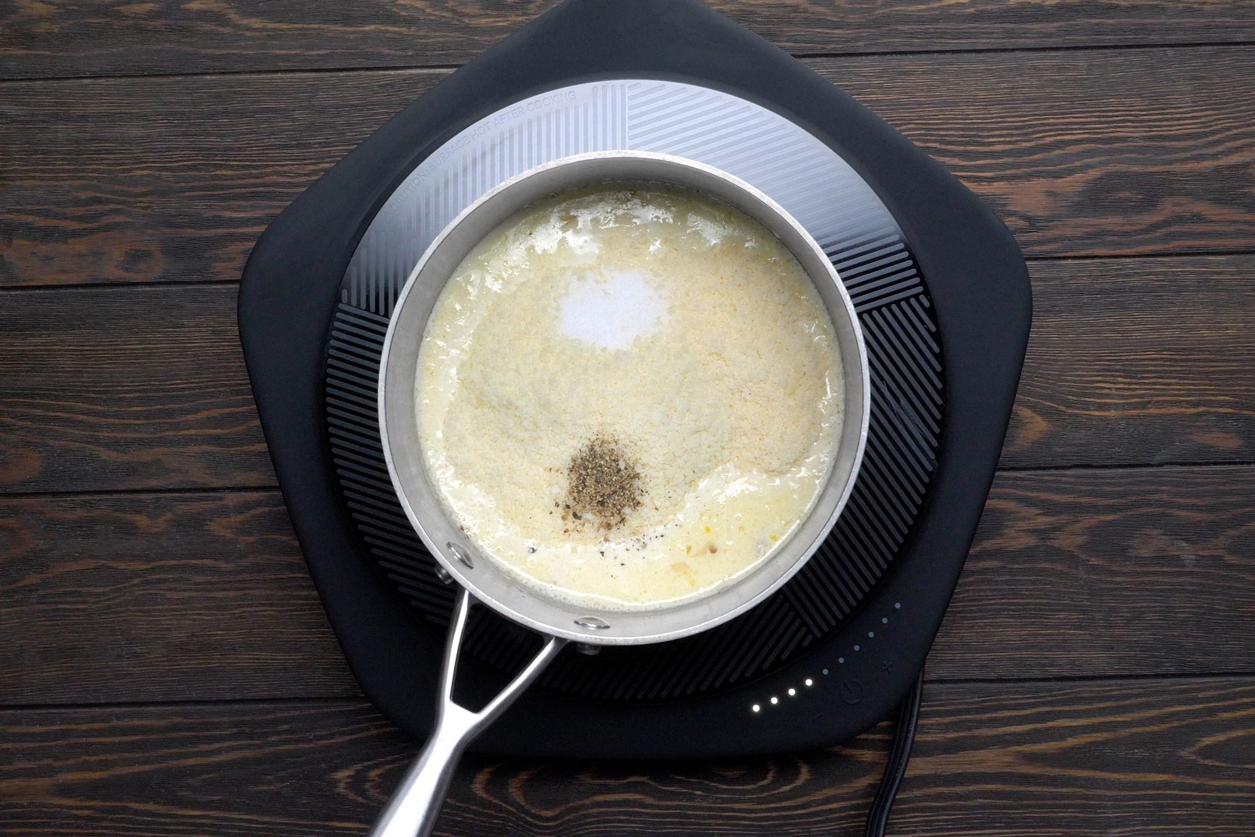 Cheeses, salt and pepper being added to the garlic, shallot and butter mixture.