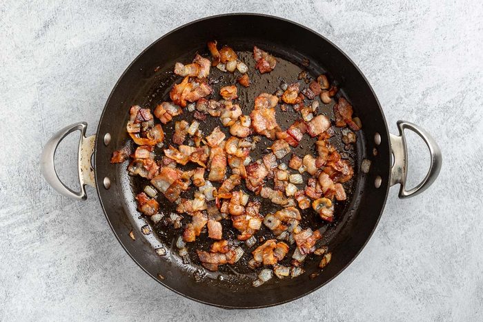 Taste of Home Bacon Pasta recipe photo of the cooked bacon and onion in a large skillet.