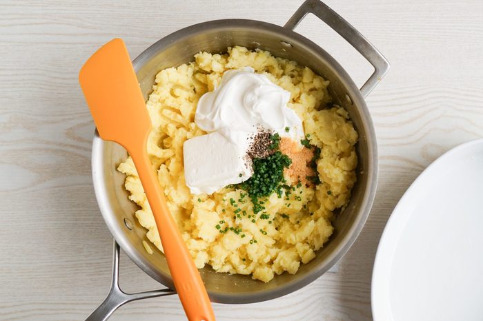 Mixing together the ingredients for baked mashed potatoes