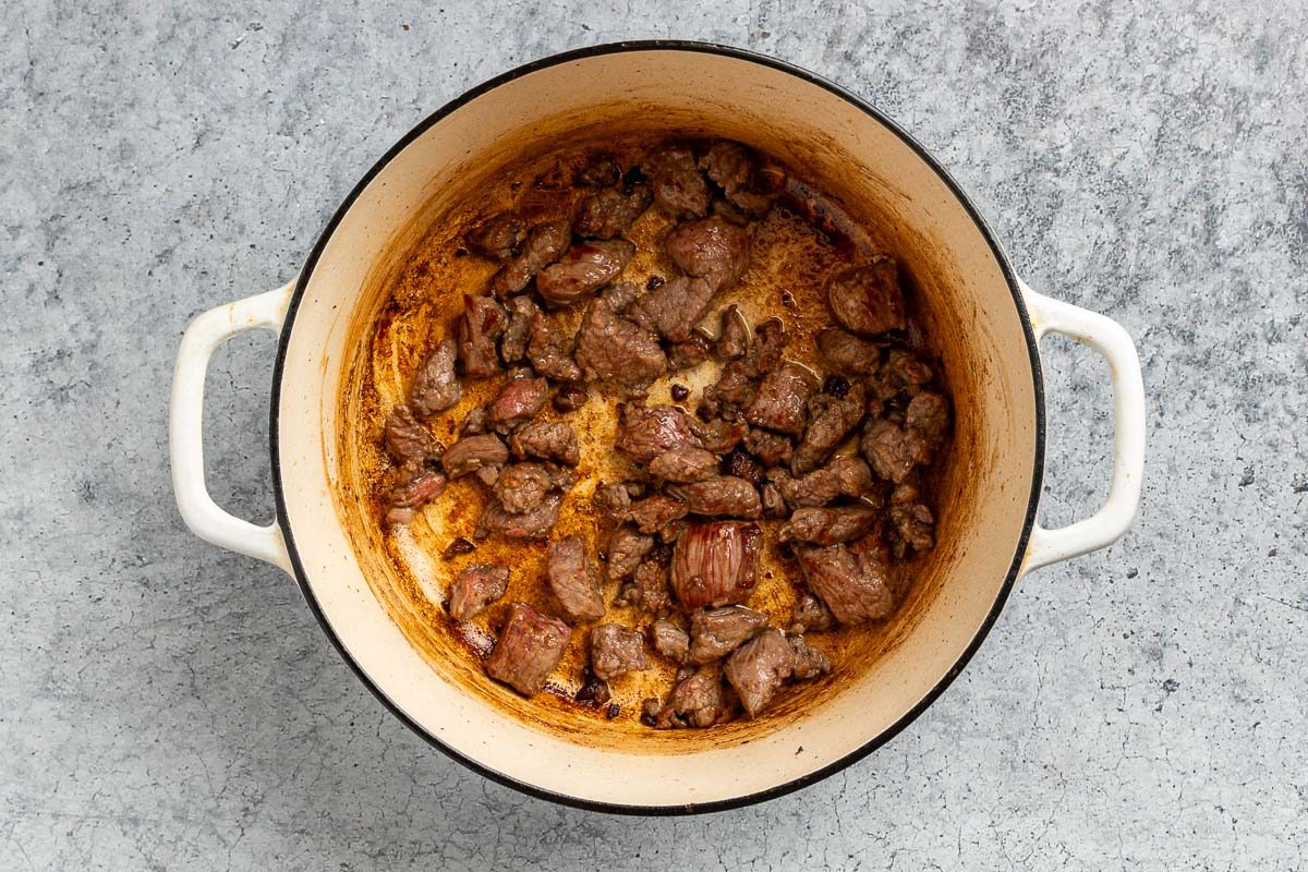 Taste of Home Beef Barley Stew recipe photo of the browned meat in a dutch oven.