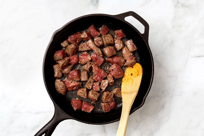 Large skillet of browning cubed steak for step two of Garlic Butter Steak Bites