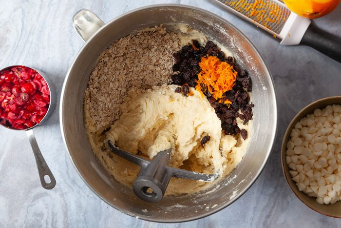 Step 1 of Taste of Home Oatmeal Cranberry Cookies is to cream the butter and sugar before adding the eggs and vanilla. Then adding the orange zest, raisins, oats, cranberries, baking chips