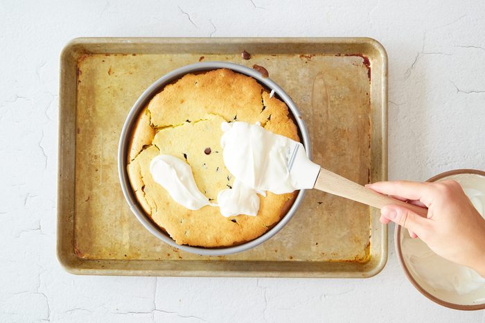 Add the sour cream layer to the chocolate chip cookie cheesecake.