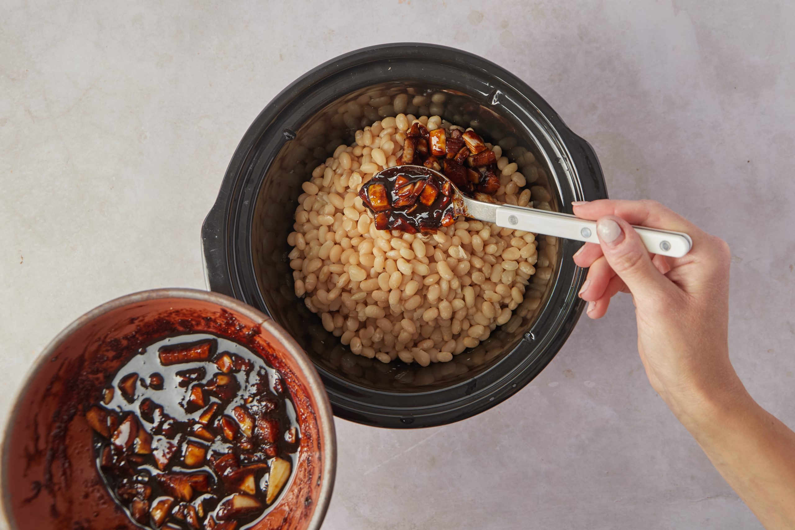 Add the beans and seasoning to a slow cooker to make vegan baked beans.