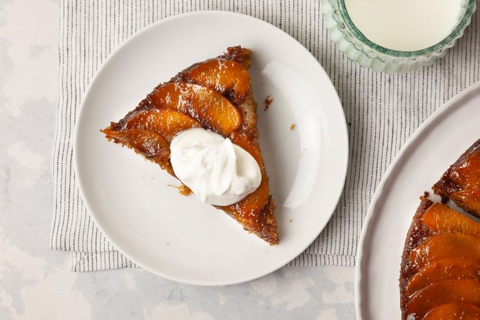 Single serving of Taste of Home Peach Upside-Down Cake garnished with whipped cream