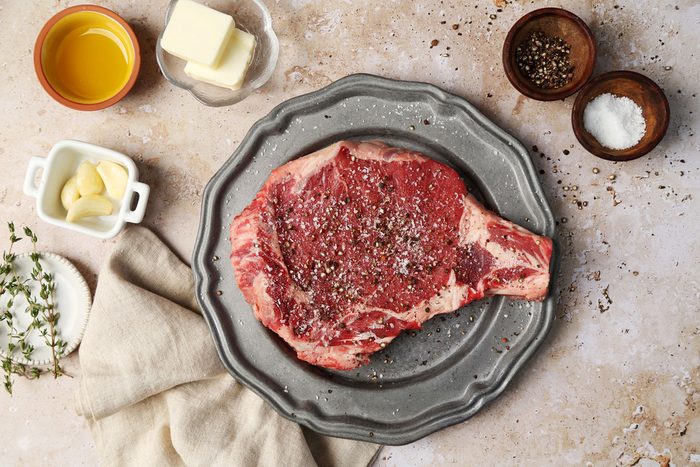 A how to look into Taste of Home's homemade Steak Frites. Steak on a plate seasoned with salt and black pepper.