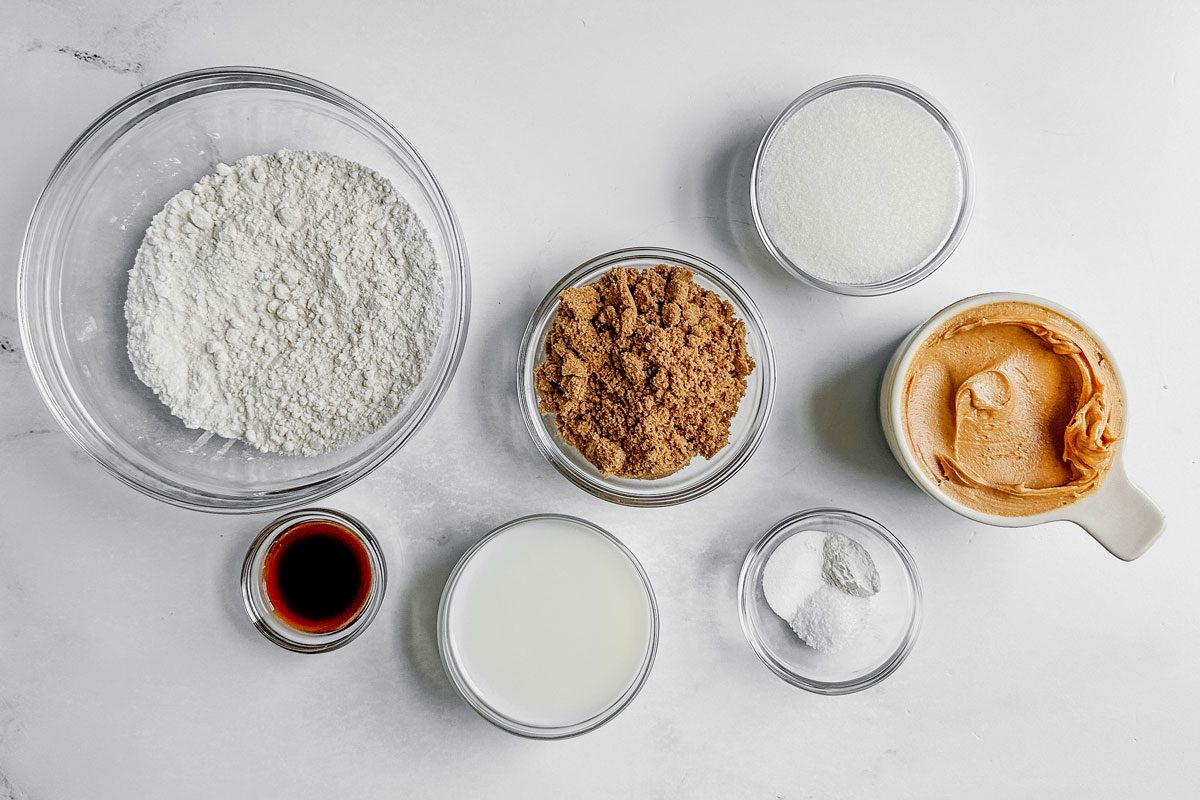 Ingredients for Taste of Home vegan peanut butter cookies in glass bowls on a marble surface.