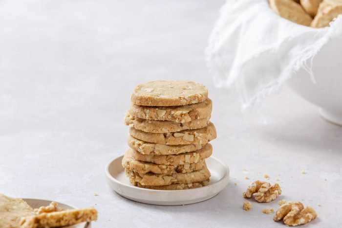 Walnut cookies piled up on small plate.